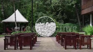 结婚。 <strong>结婚典礼</strong>。 拱门。 拱门，装饰着白花站在树林里，在婚礼区